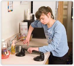girl with cerebral palsy standing at sink