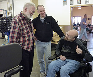 Adult Gait Trainder TBI patient Casey Breyette, a TBI patient gives the thumbs up from his wheelchair to Rifton’s helpful staff in their facility