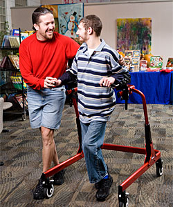 At Bakerfield ARC a therapists helps a young man with his gait training