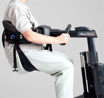 A person with muscular dystrophy shown supported by the Rifton TRAM during a toileting transfer even though they have low tone