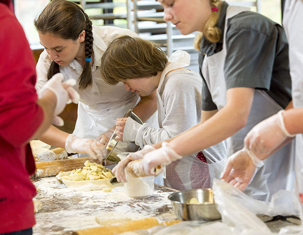 A young woman makes an apple pie at the pie booth during Rifton's birthday celebration.