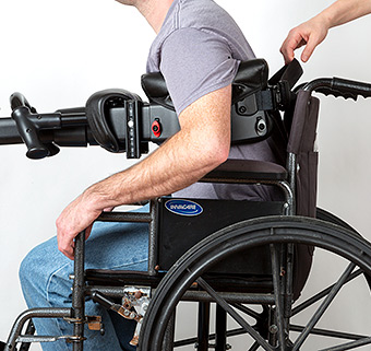 A man being transferred out of a wheelchair with a Rifton TRAM