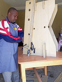 A man building a supportive stander for APT Kenya