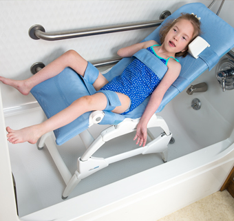 A girl sits in a Rifton Wave bath chair in a bathtub.