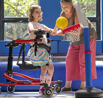 girl using Rifton Pacer playing basketball