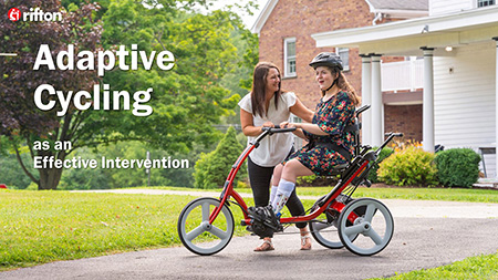 A girl pedals a Rifton Adaptive Tricycle while her caretaker walks behind her.